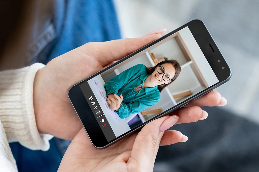 Patientin nutzt Videosprechstunde auf Smartphone mit Ärztin
